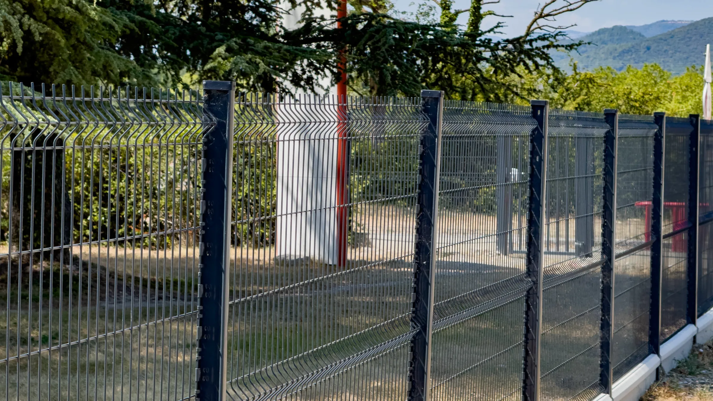 A run of 3D fence panels on notched posts, installed along a site boundary